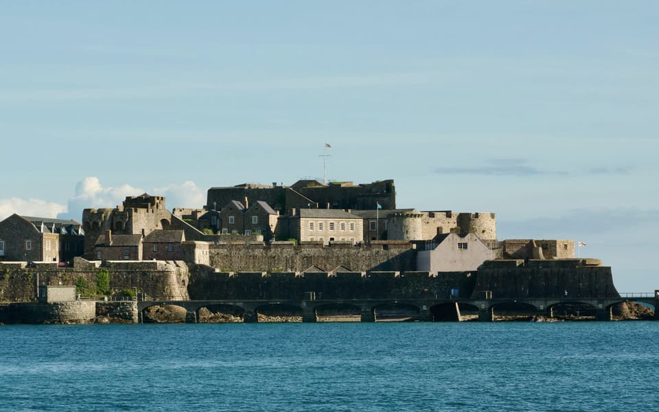 Castle Cornet across the harbour mouth on calm blue water