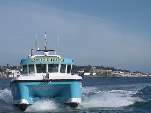 Out the Blue II, a turquoise catamaran, in St Peter Port Harbour